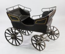 A Victorian black painted and parcel gilt child`s governess cart, with opposing seats and iron bound