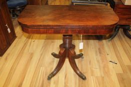 A Regency mahogany folding card table, on turned central column, downswept supports and brass