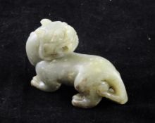 A Chinese green jade figure of a lion-dog, in standing pose with it`s head turned backward, 8.2cm.