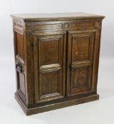 An 18th century oak cabinet, fitted two geometric panelled doors revealing single cupboard door