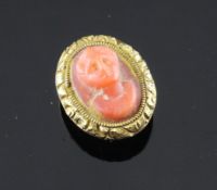 A 19th century gold and coral dress stud, of oval form, carved with the head of a lady, 0.5in.