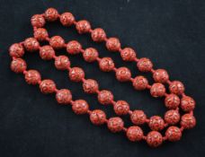 A single strand of forty two carved cinnabar lacquer beads, 31.5in.