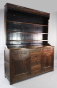 A George III oak and mahogany Welsh dresser, the open plate rack with pierced lunette frieze, the