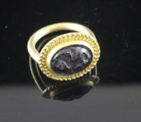 A Roman style gold and cabochon amethyst? ring, of oval form, carved with the figure of Pegasus?,