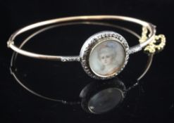 An Edwardian gold and rose cut diamond set hinged bracelet with inset painted miniature bust of a