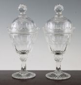 A pair of Victorian glass vases and covers, each panel cut, the bucket shaped bowls with notched