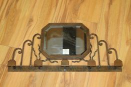 A French Art Deco wrought iron mirrored wall bracket, in the manner of Edgar Brandt with six coat