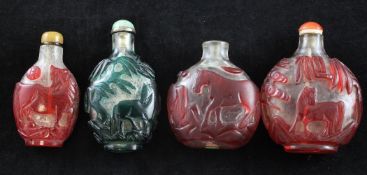 Four Chinese single colour overlay glass `horse` snuff bottles, 19th / 20th century, three in red