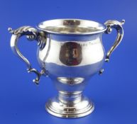 An Edwardian silver two handled presentation trophy cup, with acanthus leaf capped scroll handles