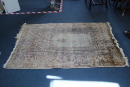 A Turkish prayer rug, the central mihrab with hanging lamp and foliate borders, on an ivory