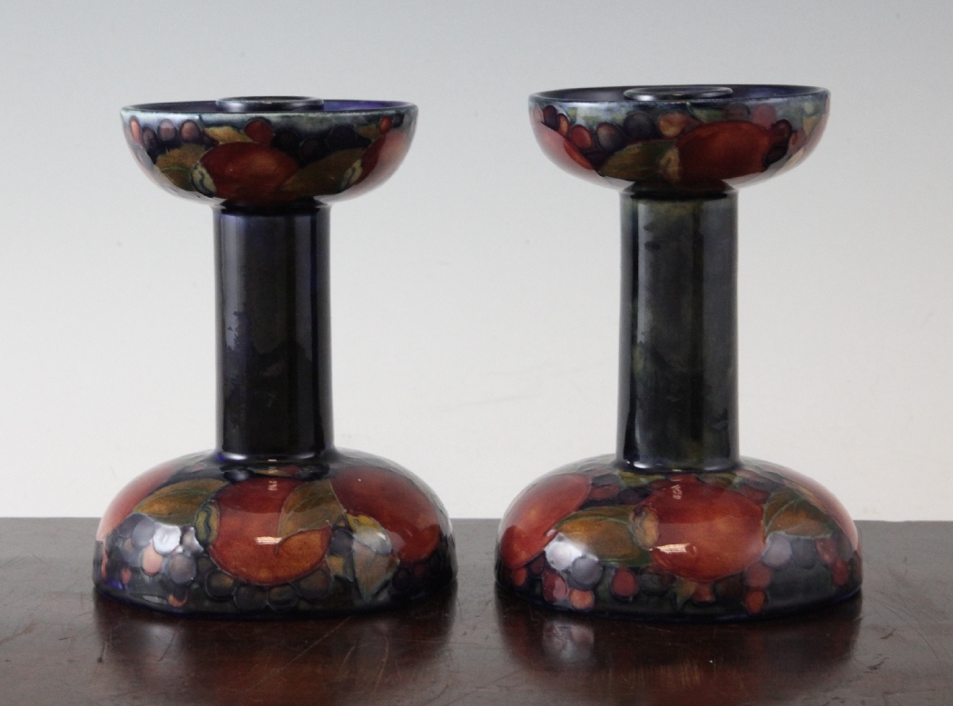 A pair of Moorcroft Pomegranate candlesticks, c.1920, of unusual form, with domed bases and