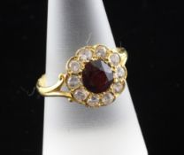 An Indian? high carat gold, garnet and white sapphire? cluster ring, the central stone bordered by