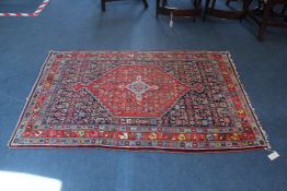 A Persian rug, with central stepped motif within a foliate field, on a red and blue ground with