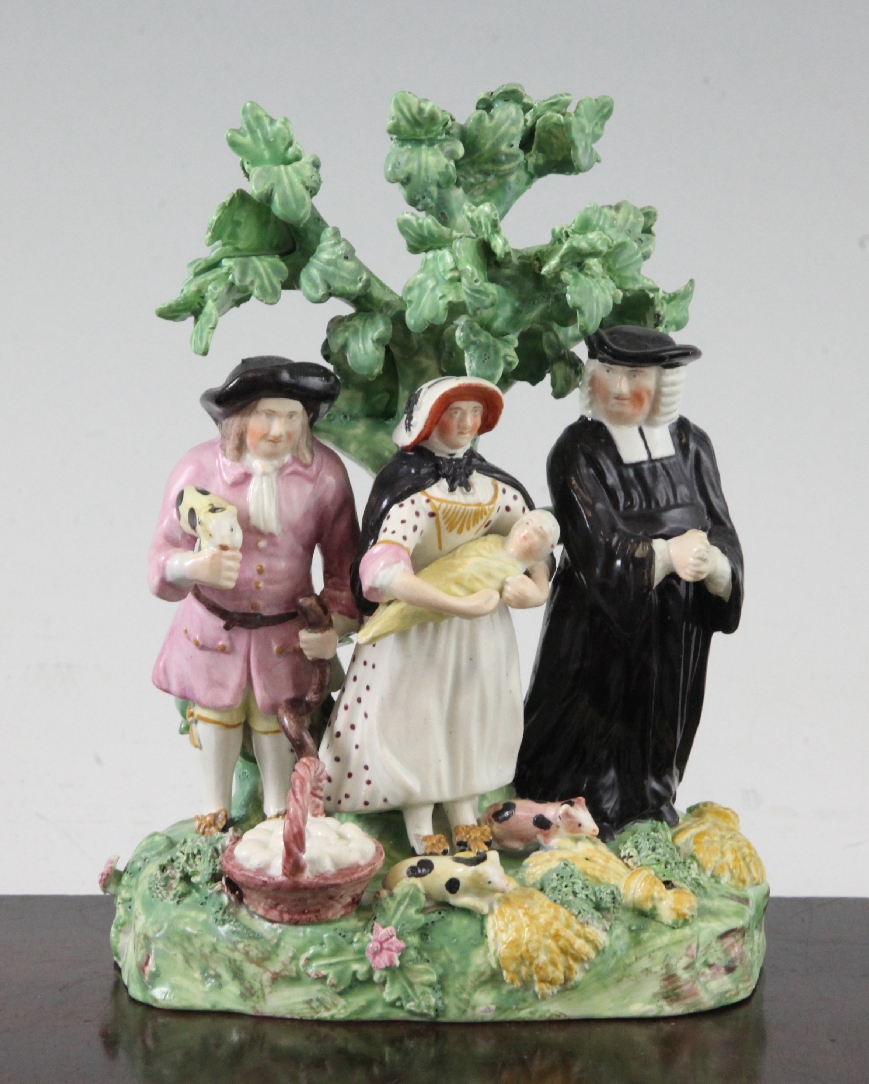A Staffordshire pearlware Tithe pig group, c.1820, each of the figures standing before a tree, on