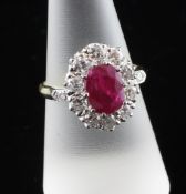 An 18ct gold, ruby and diamond cluster ring, of oval form, the central ruby weighing approximately