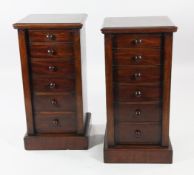 A pair of mahogany pedestal cupboards, the single door modelled as six drawers with bun handles,