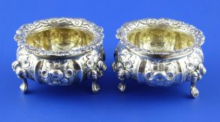 A pair of George IV silver bun salts, with embossed foliate decoration, on stump feet, J.