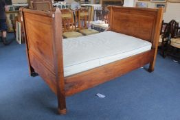 A 19th century French fruitwood bed, with ormolu mounts and large panelled ends, overall 6ft 9in.