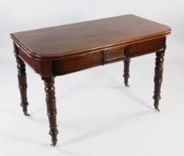 An early 19th century mahogany extending table, with rounded ends and ring turned supports, the