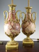 A pair of French ormolu mounted marble table lamps, with ovoid pear shaped bodies, swan neck handles