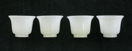 A set of four Chinese celadon-white jade miniature cups, 20th century, each 2.5cm.