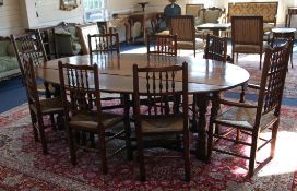 A large 18th century style oak oval wake table, with drop leaves and turned supports, united by