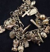 A 9ct gold curb link charm bracelet, hung with twenty seven assorted charms, gross 51 grams.
