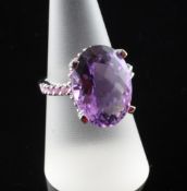 A 14ct white gold, fancy oval cut amethyst and pink sapphire dress ring, with claw set amethyst
