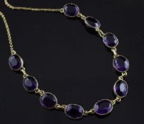 An early 20th century 9ct gold and amethyst fringe necklace, set with ten oval cut stones, 16in.