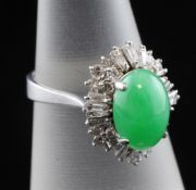 A platinum, cabochon jadeite and diamond ring, the central cabochon bordered by trapeze and round