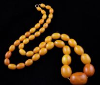 A single strand graduated oval amber bead necklace, gross 99 grams, 32in.