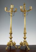 A pair of late 19th century Empire style three branch candelabra, with tapering reeded stiff leaf