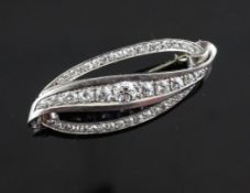 An Austrian 14ct white gold and diamond brooch, of stylised leaf form, the diagonal set with