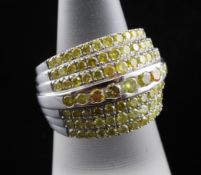 A white gold and seven row graduated diamond set dress ring, with six rows of yellow diamonds and