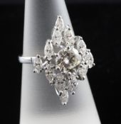 An 18ct white gold and diamond cluster ring, of navette form, the central round cut diamond weighing