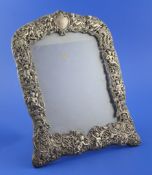 An Edwardian pierced silver mounted photograph frame by William Comyns, embossed with cherubs
