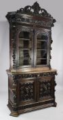 A Victorian heavily carved oak bookcase, with acanthus scroll pierced pediment over two glazed
