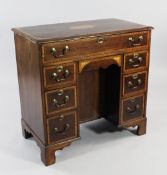 A George III mahogany and satinwood crossbanded kneehole desk, with paterae inlay, with a recessed