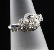 A platinum, sapphire and diamond set dress ring, with raised central round cut claw set diamond