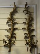 A pair of carved giltwood wall sconces, modelled as leafy scrolls with twin branch candle holders,