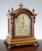 An early 20th century gilt brass mounted walnut bracket clock, with arched dial and German