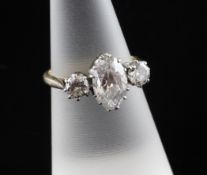 An 18ct gold, platinum and three-stone diamond ring, with central marquise shaped diamond weighing