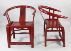 Two similar red lacquered Chinese horseshoe armchairs, with single splat back and inset panel seats