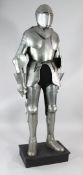 A reproduction suit of armour, on rectangular plinth base, 6ft 3in.