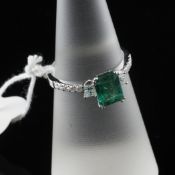 A 14ct white gold, emerald and diamond set dress ring, with emerald cut stone and round and princess