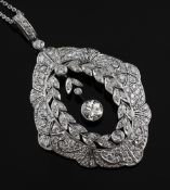 A Victorian style white gold and diamond set pendant. of shaped oval form with foliate and fan