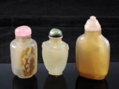 Three Chinese chalcedony snuff bottles, 1850-1920, the first cylindrical carved in relief with a