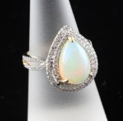A 14ct gold, diamond and pear shaped white opal set dress ring, the opal bordered by two