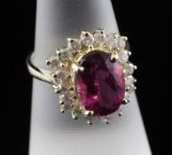 A 14ct gold, pink tourmaline and diamond cluster ring, the oval cut tourmaline weighing 3.00ct and