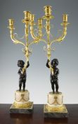 A pair of late 19th century French bronze and ormolu candelabra, modelled as a standing cherub